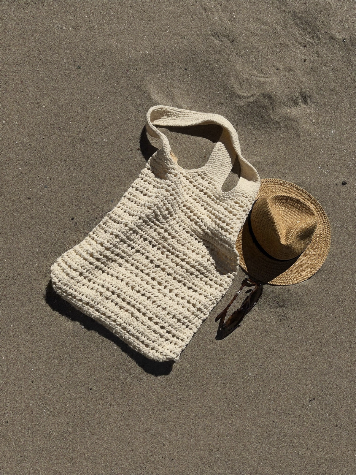 Grand tote bag de plage au crochet en coton écru sur le sable