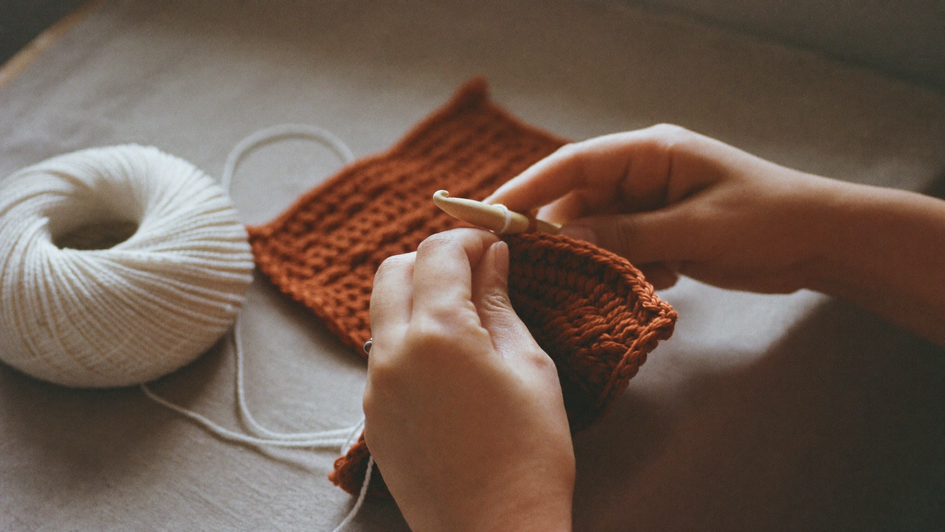 Mains en train de crocheter un carré granny square au crochet en bois